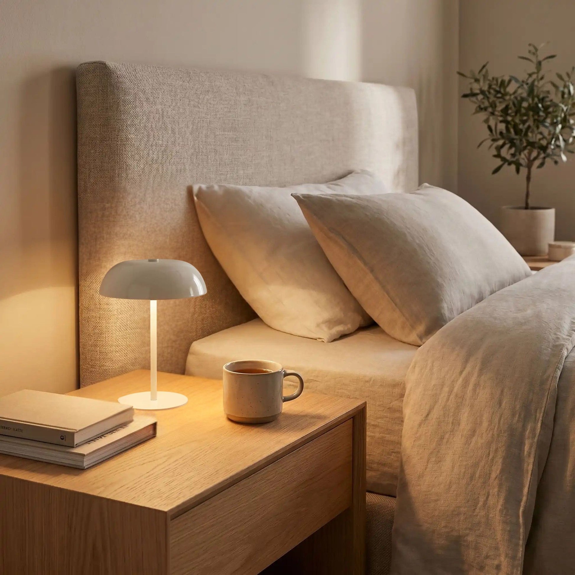 Lampe champignon sans fil Rechargeable 3 ambiances sur table de chevet avec tasse et livres.